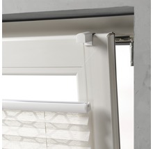 Detailweergave van een plisségordijn op het raam met bedieningselement