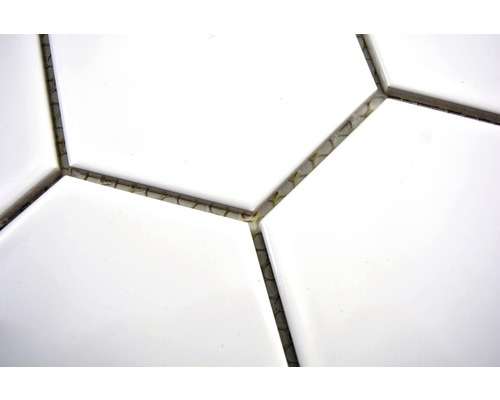 Close-up van witte, zeshoekige tegels met voegmiddel