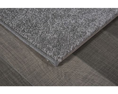 Detailopname van een grijs tapijt op een houten vloer