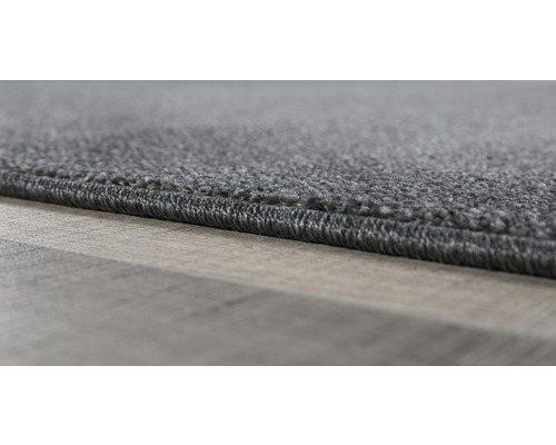Detailopname van een grijs tapijt met afgewerkte randen