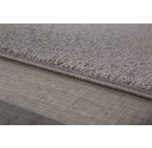 Detailopname van een grijs tapijt op een houten vloer