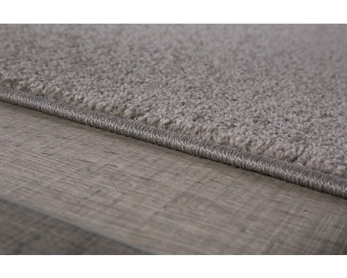 Detailopname van een grijs tapijt op een houten vloer