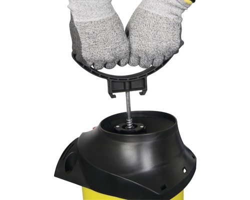 Handen met beschermende handschoenen monteren een handgreep op een drukspuit.