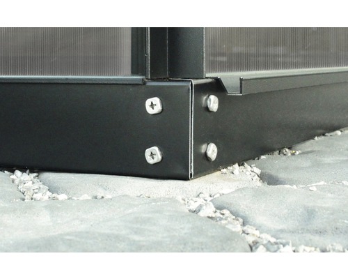 Detailopname van een metalen kasconstructie met schroeven op een stenen vloer.