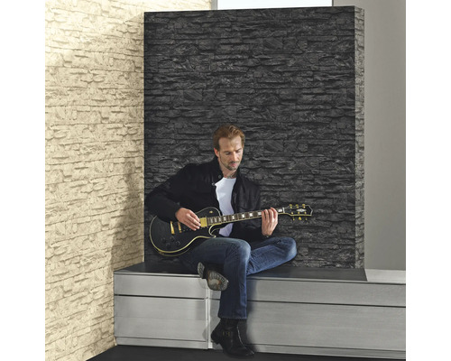 Man speelt gitaar voor een muur met steenmotief behang