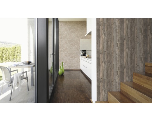 Lichte, georganiseerde binnenruimte met houten vloer, trap en een wandbehang met houtlook.