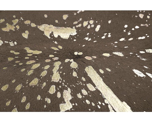 Close-up van een bruin vloerkleed met zilverkleurige verfspatten.