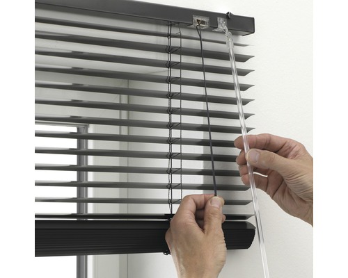 Persoon bedient jaloezie ter raamdecoratie