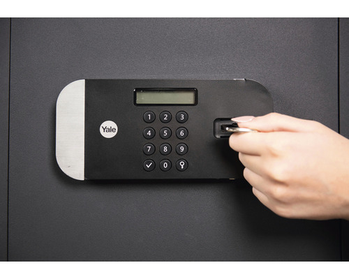 Een kluis met een digitaal toetsenpaneel wordt geopend met een sleutel. Yale Logo
