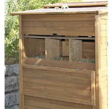 Detail van een kippenhok met houten legnest