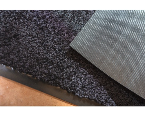 Detailopname van een schoonloopmat met een gestructureerd oppervlak en een antislip achterkant