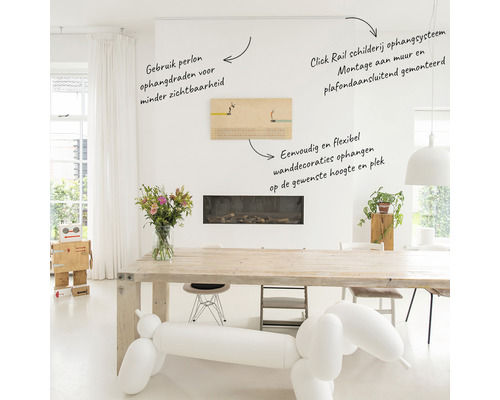 Lichte ruimte met Click Rail schilderij ophangsysteem, gemonteerd aan wand en plafond. Perlon ophangdraden zorgen voor minder zichtbaarheid bij het flexibel ophangen van wanddecoraties op de gewenste hoogte.