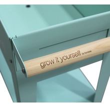 Detailweergave van een kruidenwagen met houten handgreep en de tekst Grow it yourself by herstera