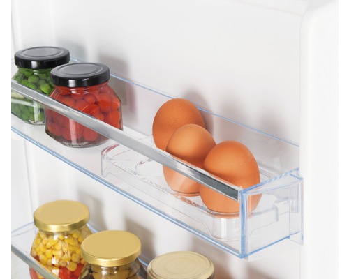 Gedetailleerde foto van een koelkast met conserven en eieren in de schappen