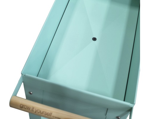 Close-up van een plantentafel met metalen bak en houten handvat