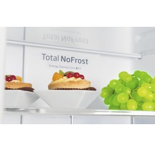 Interieur van een koelkast met de tekst Total NoFrost en energie-efficiëntieklasse A++, met gebak en druiven.