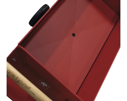 Detailopname van een rode bolderkar met handvat en wiel