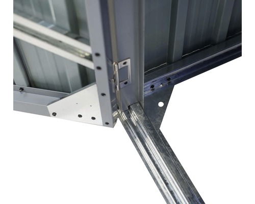 Detail van een metalen tuinhuis met deurscharnier en hoekverbindingen