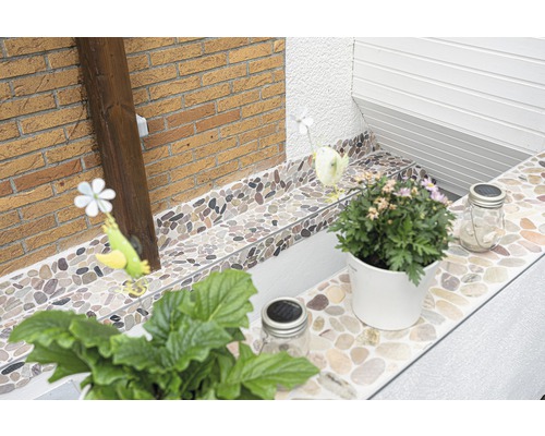 Decoratieve steentegels verfraaien een buitenruimte met planten en decoraties.