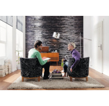 Woonkamer met twee personen in fauteuils, staande lamp en decoratie op een tapijt