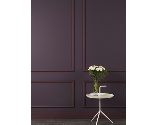 Wanddecoratie met sierlijsten en witte bijzettafel met bloemenvaas