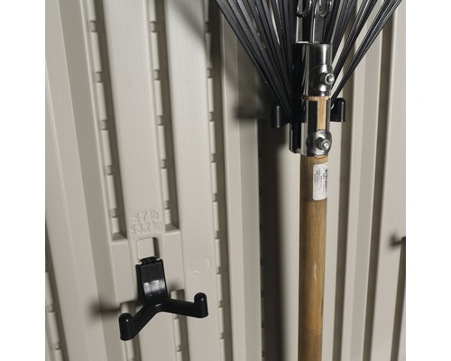 Tuingereedschaphouder aan een beige kunststof wand met een bladblazer