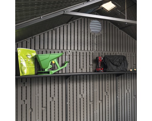 Binnenaanzicht van een tuinhuis met planken en tuingereedschap