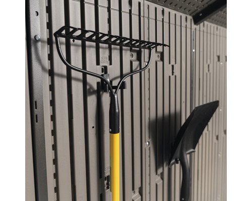 Tuinhark met gele steel en schop, bevestigd aan een opslagwand