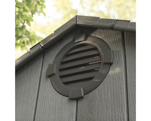 Detail van een tuinhuis met een ronde ventilatieopening