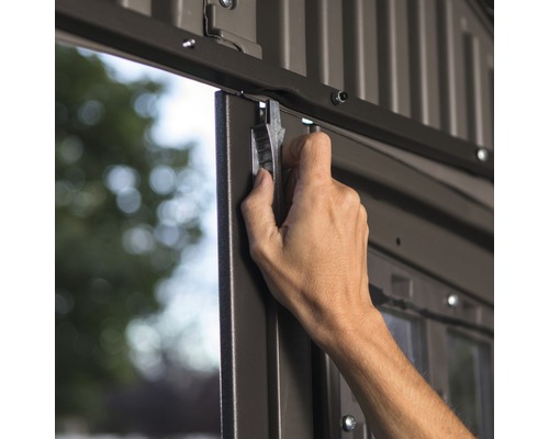 Hand sluit metalen deur van een tuinhuis