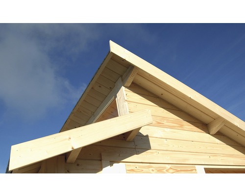 Detailaanzicht van een houten huis met een puntgevelconstructie tegen een blauwe lucht