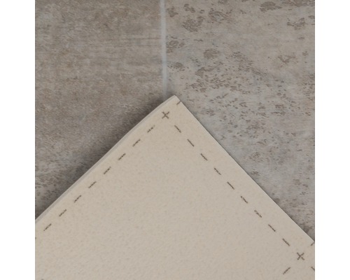 Detailweergave van een tapijt met gestikte randen op een tegelvloer.