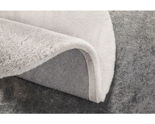 Detailweergave van een lichtgekleurd tapijt met textielrug