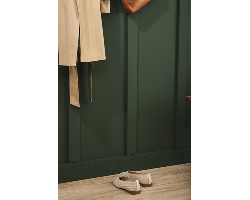 Garderobe met beige jas, tas en schoenen voor een groene wand met houten lambrisering
