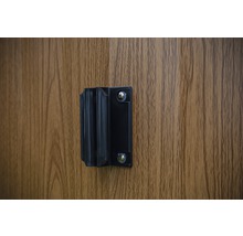 Zwarte houder voor infraroodcabines op een houten wand