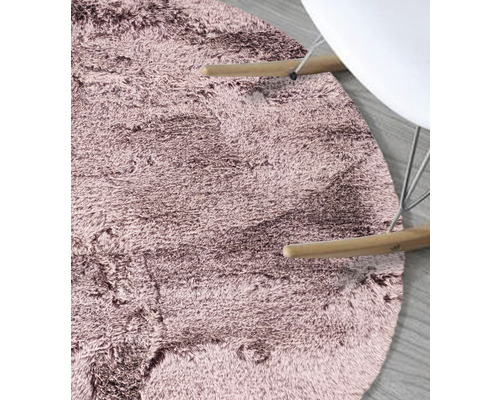 Gedetailleerde weergave van een rond, laagpolig tapijt naast een stoel