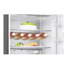 Interieur van een koelkast met flessenhouder, taart, kaas en fruit