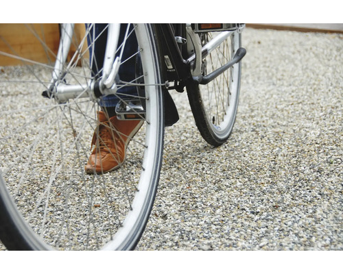 Close-up van een fiets met persoon op een grindpad