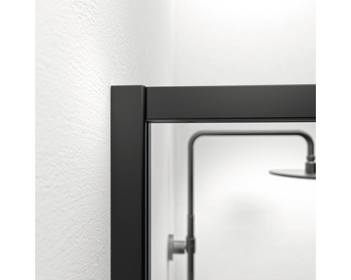 Detailopname van een douchecabine met zwart frame en douchekop