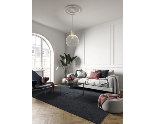 Woonkamer met bank, fauteuil, salontafel, hanglamp en vloerkleed op parketvloer