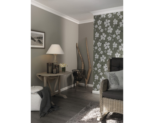 Woonkamer met houten vloer, bloemendecoratie behang en houten meubels.