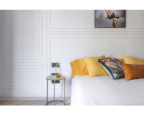 Slaapkamer met bed, kussens en nachtkastje