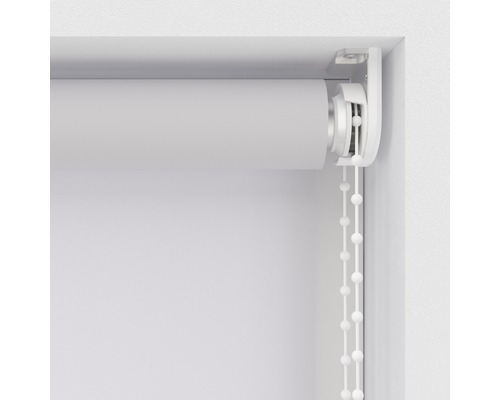 Gedetailleerde weergave van een wit rolgordijn met kettingbediening bij het raam