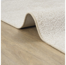 Gedetailleerde weergave van een beige tapijt op een houten vloer