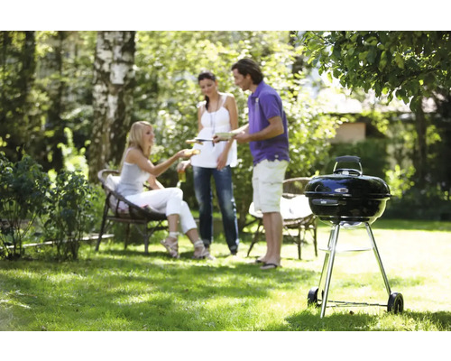 Scene van een barbecue in de tuin met een houtskoolgrill
