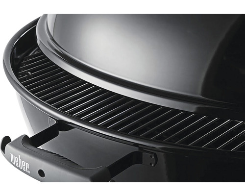 Detail van een houtskoolgrill met grillrooster en deksel.