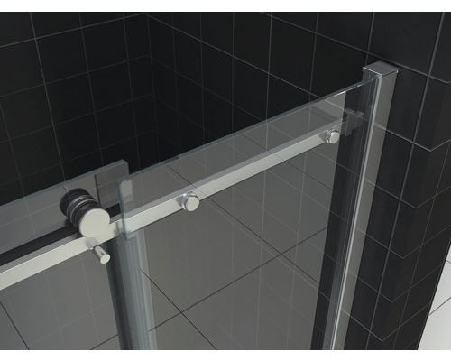 Detailopname van een douchecabine met schuifdeur en metalen beslag tegen een donkere achtergrond