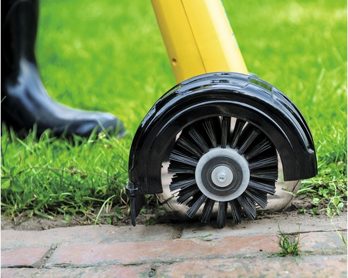 Detailopname van een voegenborstel die straatstenen reinigt