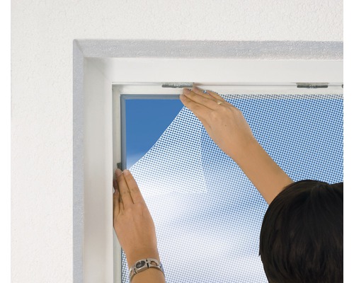 Persoon bevestigt een insectenhor aan een raam