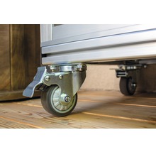 Wielen met rem op een metalen frame op een houten vloer